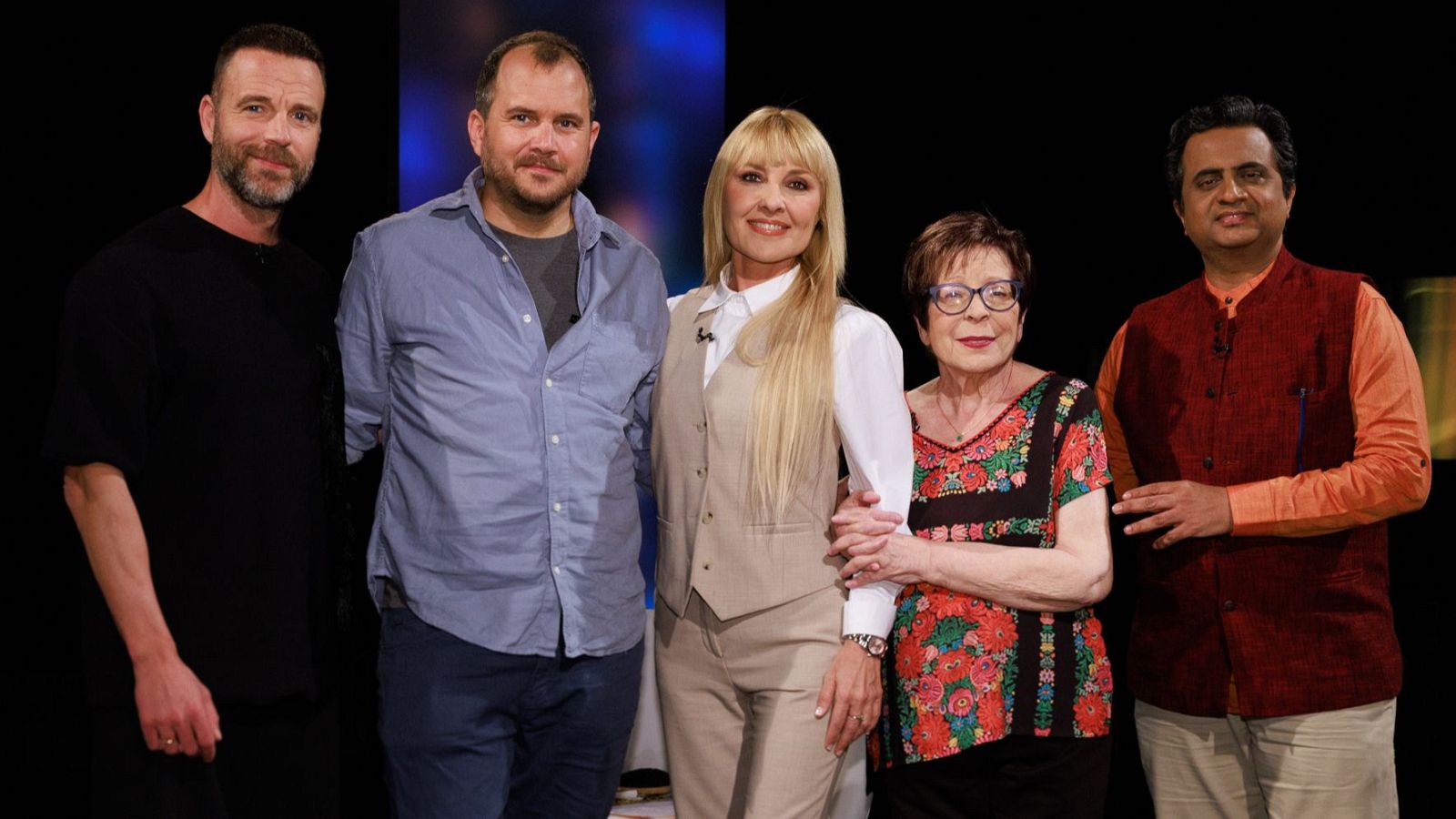 Anne Igartiburu y Ramiro Calle posan junto a otras tres personas en un plató con luz azul. Todos sonríen a la cámara.