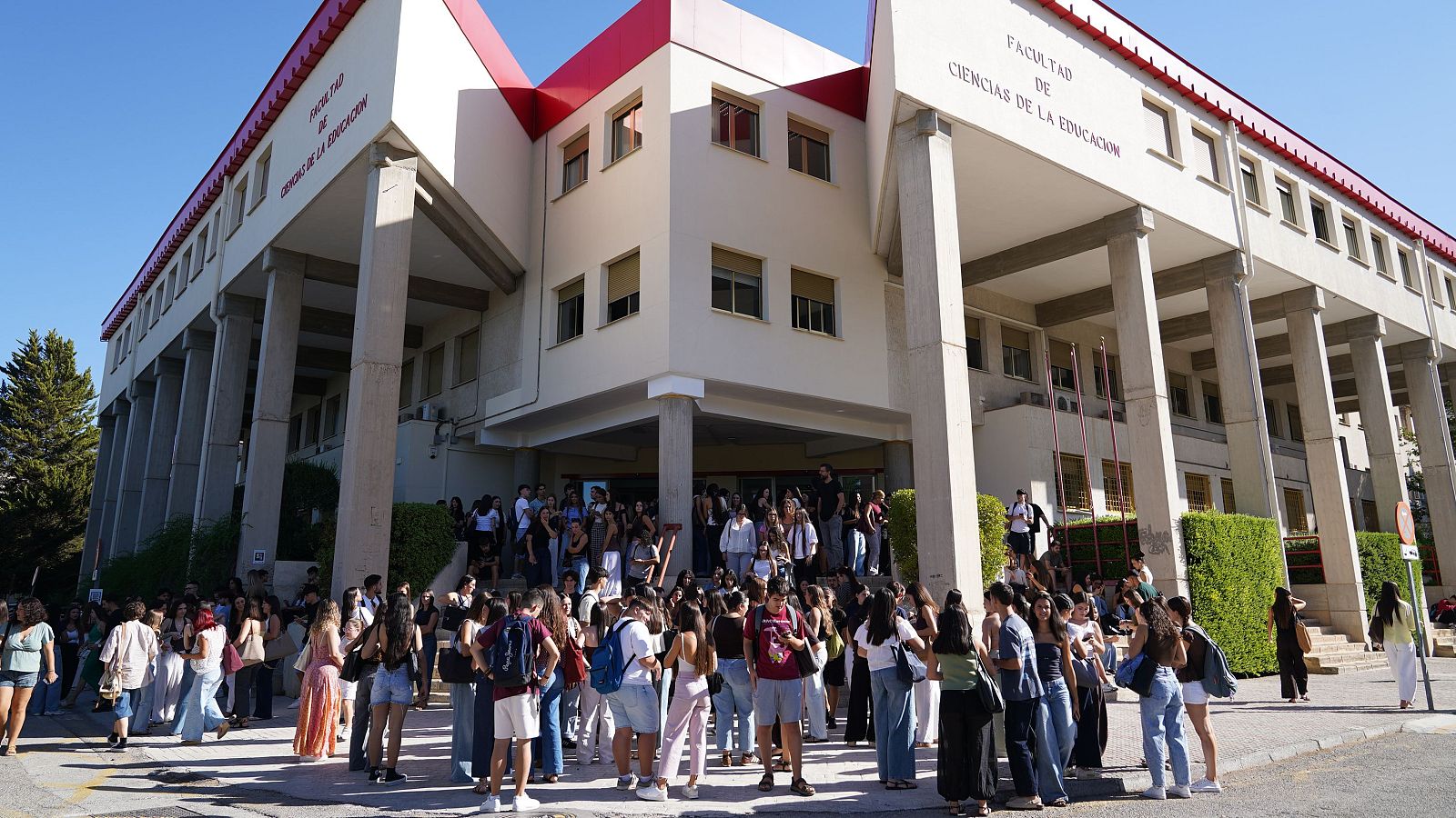 Estudiantes y profesores guardan un minuto de silencio con pancartas en las puertas de un edificio de la Universidad de Granada en homenaje a Claudia Tacoronte.