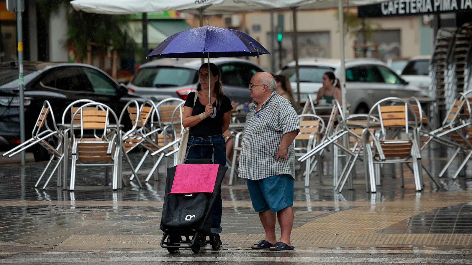 Dos personas se protegen de la lluvia en Valencia, en una imagen de archivo