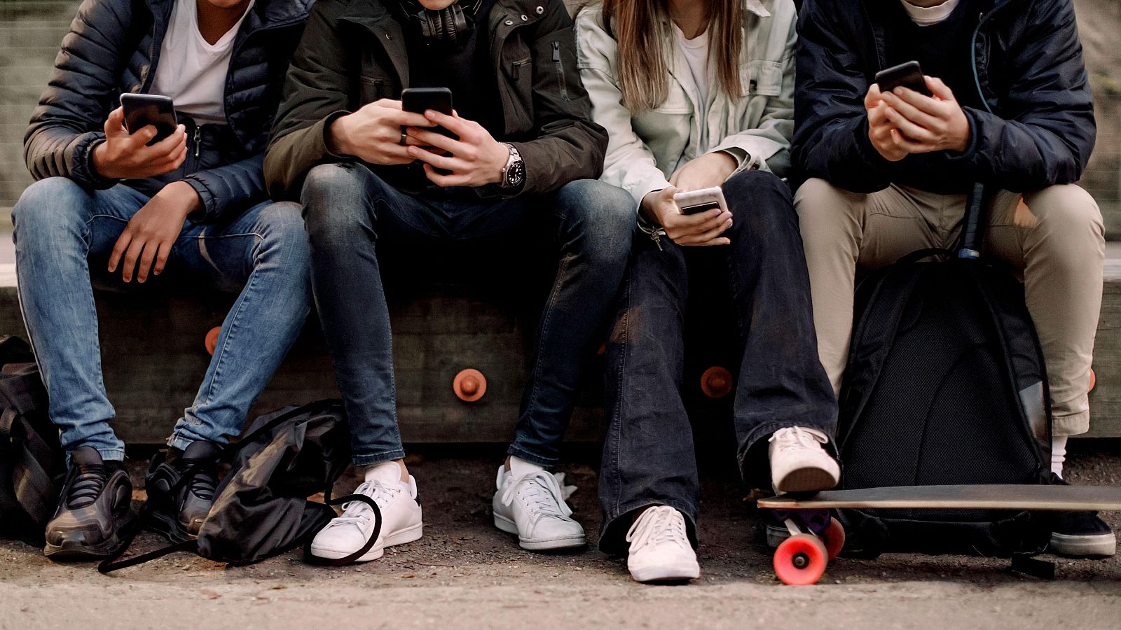 Adolescentes utilizan sus teléfonos móviles ante el anuncio de nuevas restricciones europeas a las redes sociales para menores