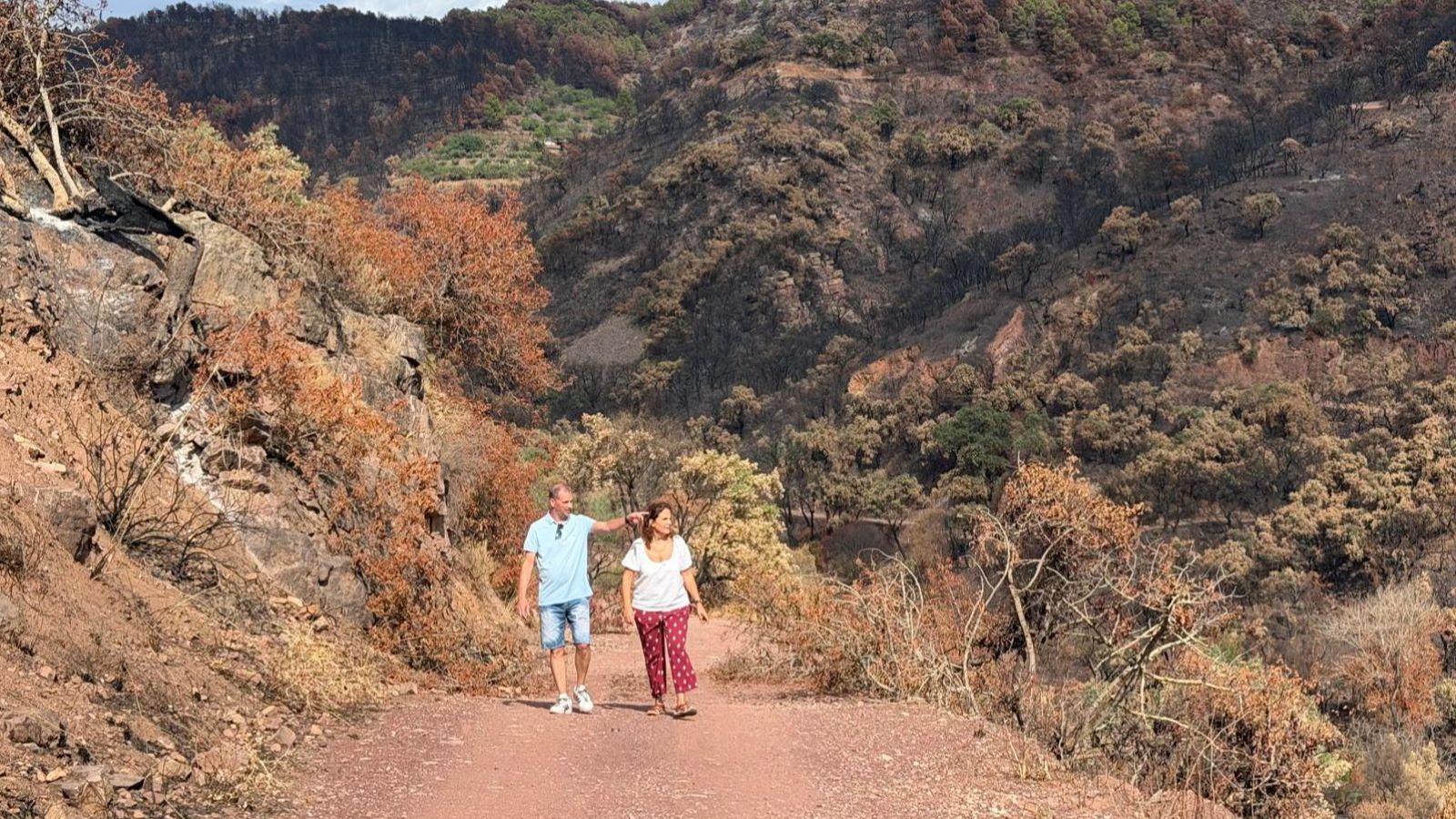 Los periodistas Eloi Martínez y Gemma Gumán caminan por una de las zonas afectadas por el incedio de la Vall d'Uixó