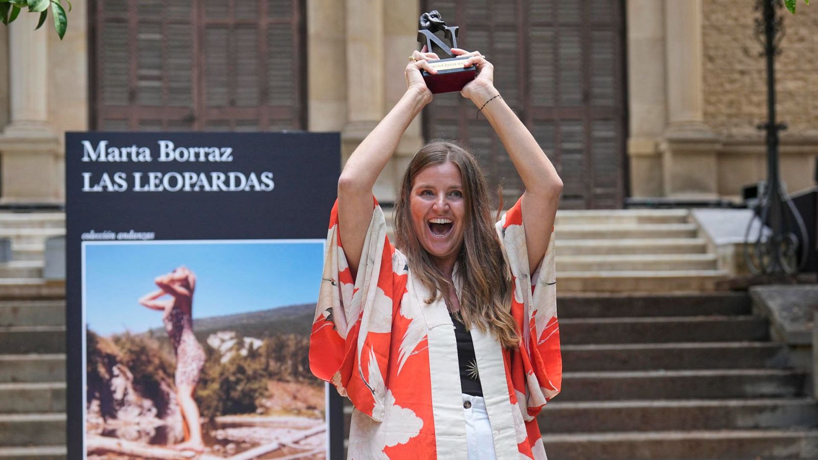 Marta Borraz alza el Premio Tusquets junto a la portada de su novela 'Las leopardas'