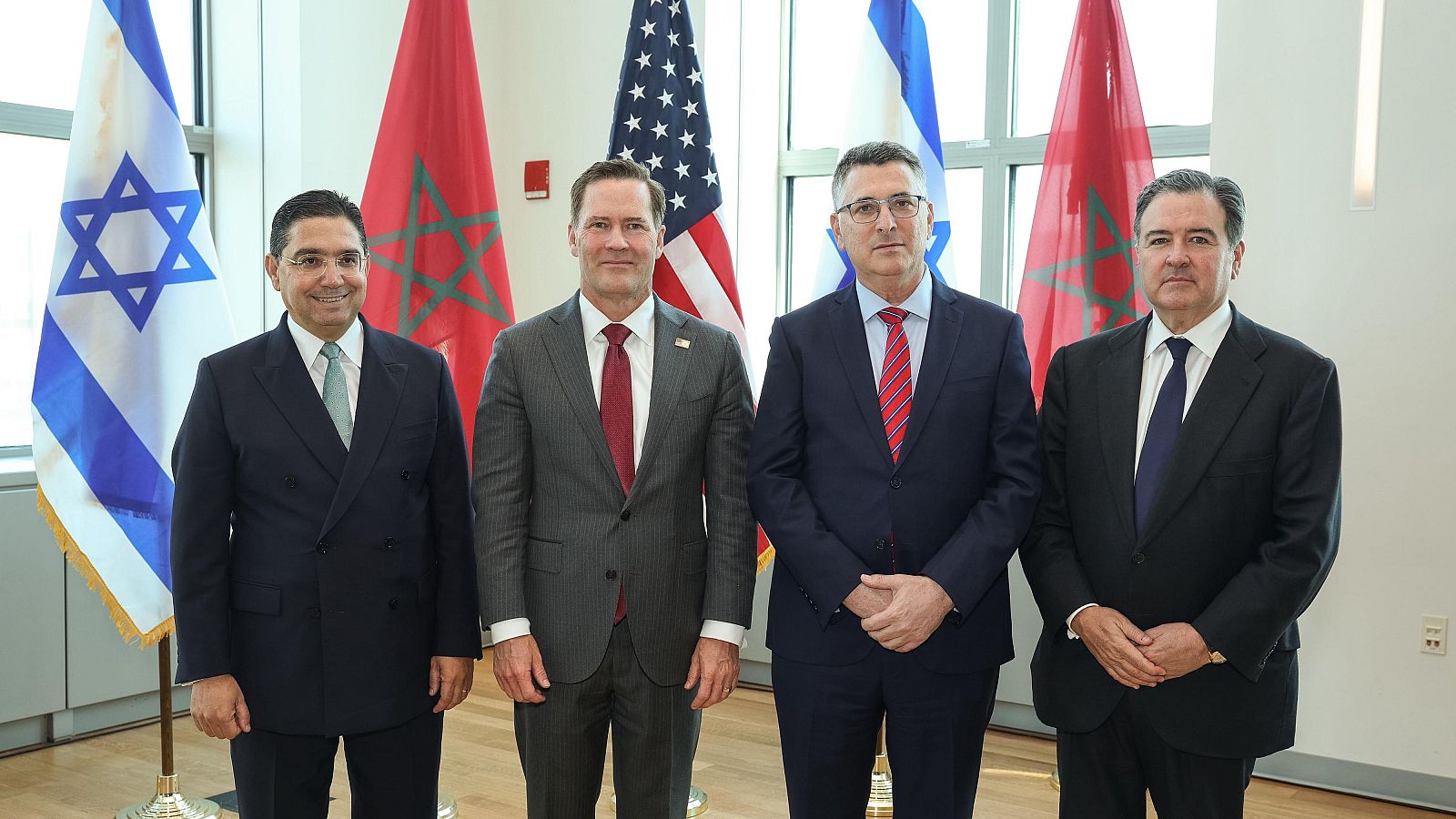 Cuatro hombres posan con banderas de Israel, Marruecos y EE. UU. en Nueva York el 16/09/2026. Se identifican Naser Burita, Michael Waltz y Gideon Saar.