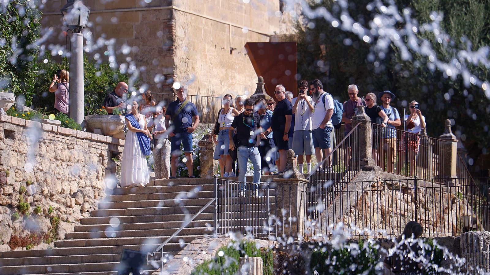 Turistas paseando por las fuentes jardines del Alcázar.