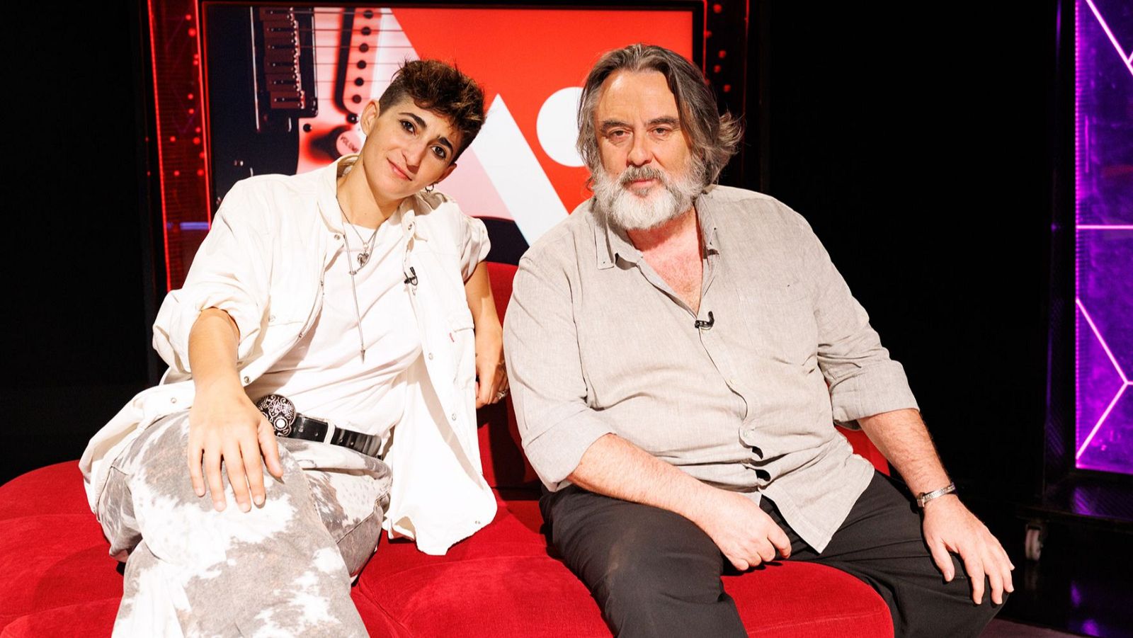 Alba Flores y Andrés Lima posan en un sofá rojo en un estudio de La 2, con iluminación de estudio y elementos gráficos de fondo. Fotografía de Roberto Moreno Moya del 26/09/2019.