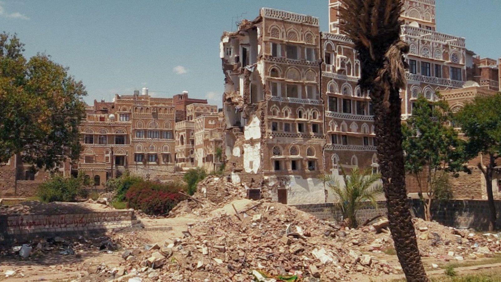 Edificio yemení en Sana'a, Yemen, destruido por bombardeos. Escombros y vegetación en un paisaje desolador.