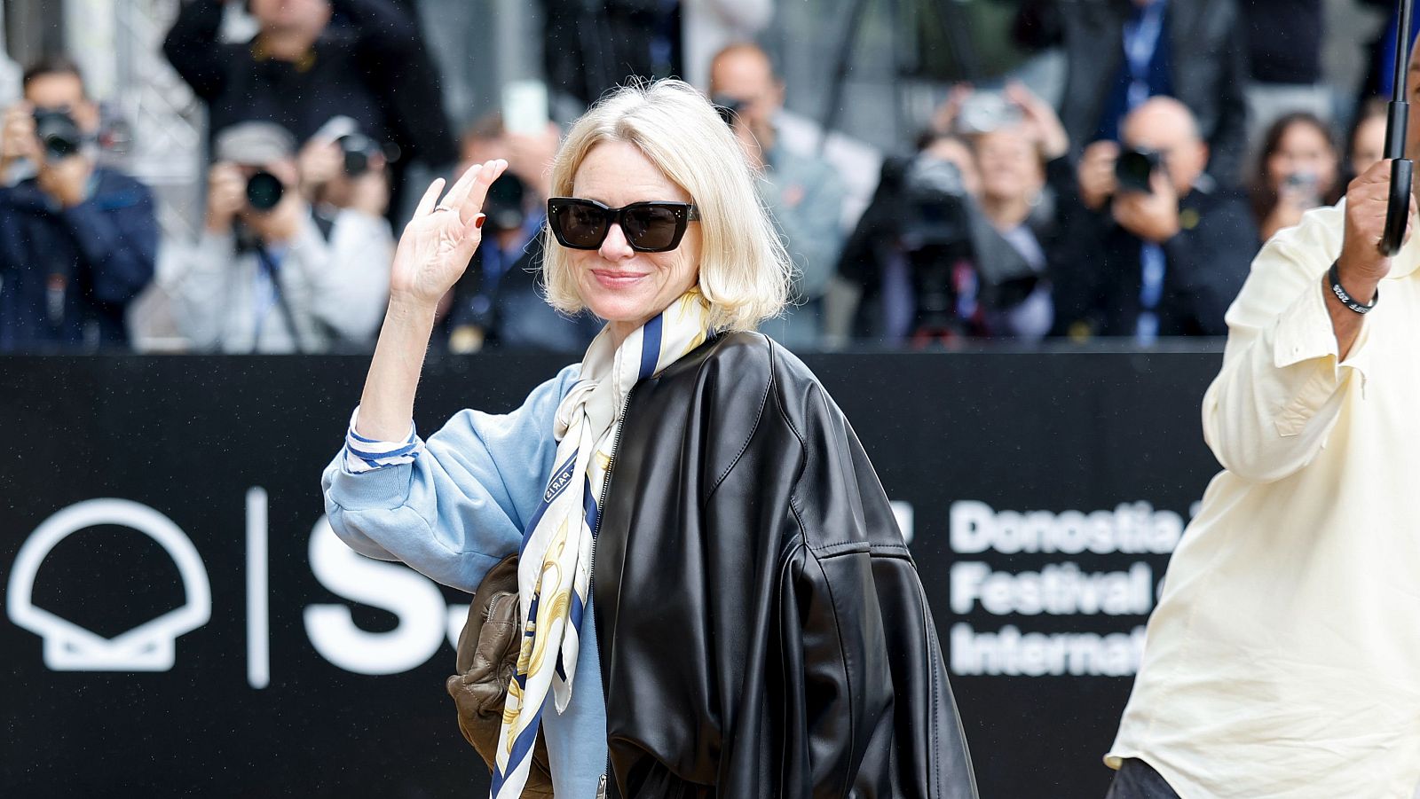 Naomi Watts, con gafas de sol y pañuelo estampado, saluda en el Festival Internacional de Cine de Donostia.