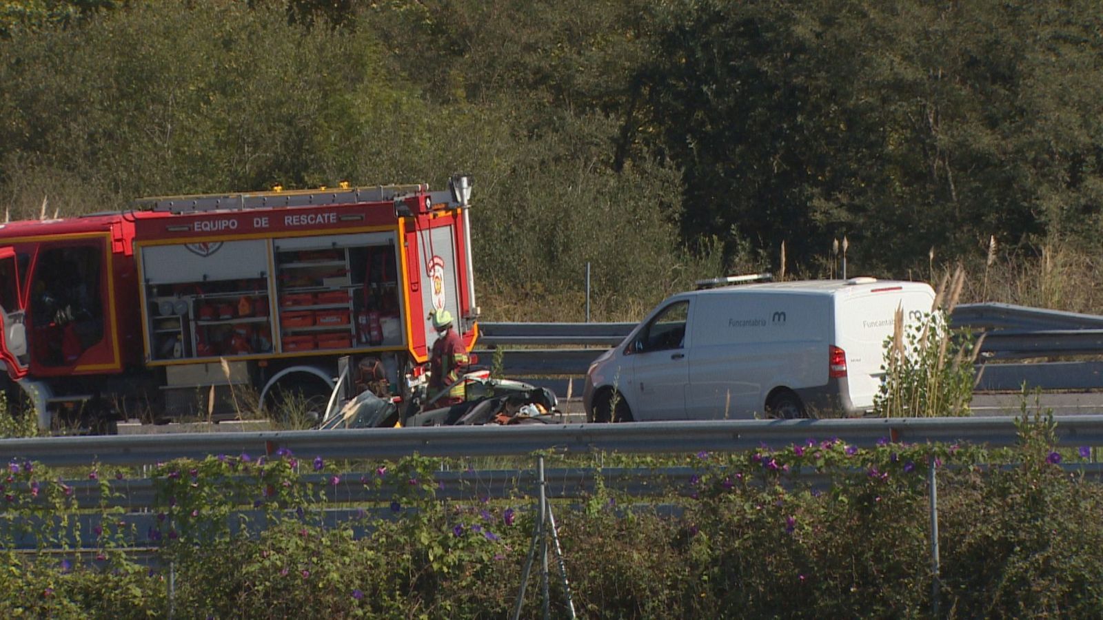 Accidente de tráfico con camión de bomberos, bombero, restos de vehículo, furgoneta "Mutua" y vegetación.