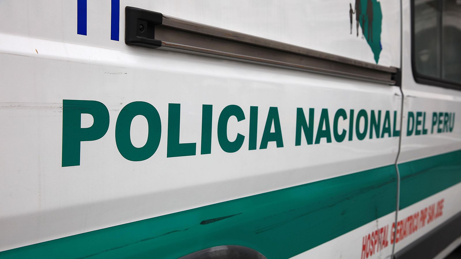 Lateral de vehículo policial peruano blanco con inscripción "POLICIA NACIONAL DEL PERU" en verde oscuro, franja verde inferior y gráfico de mapa en la parte superior izquierda.
