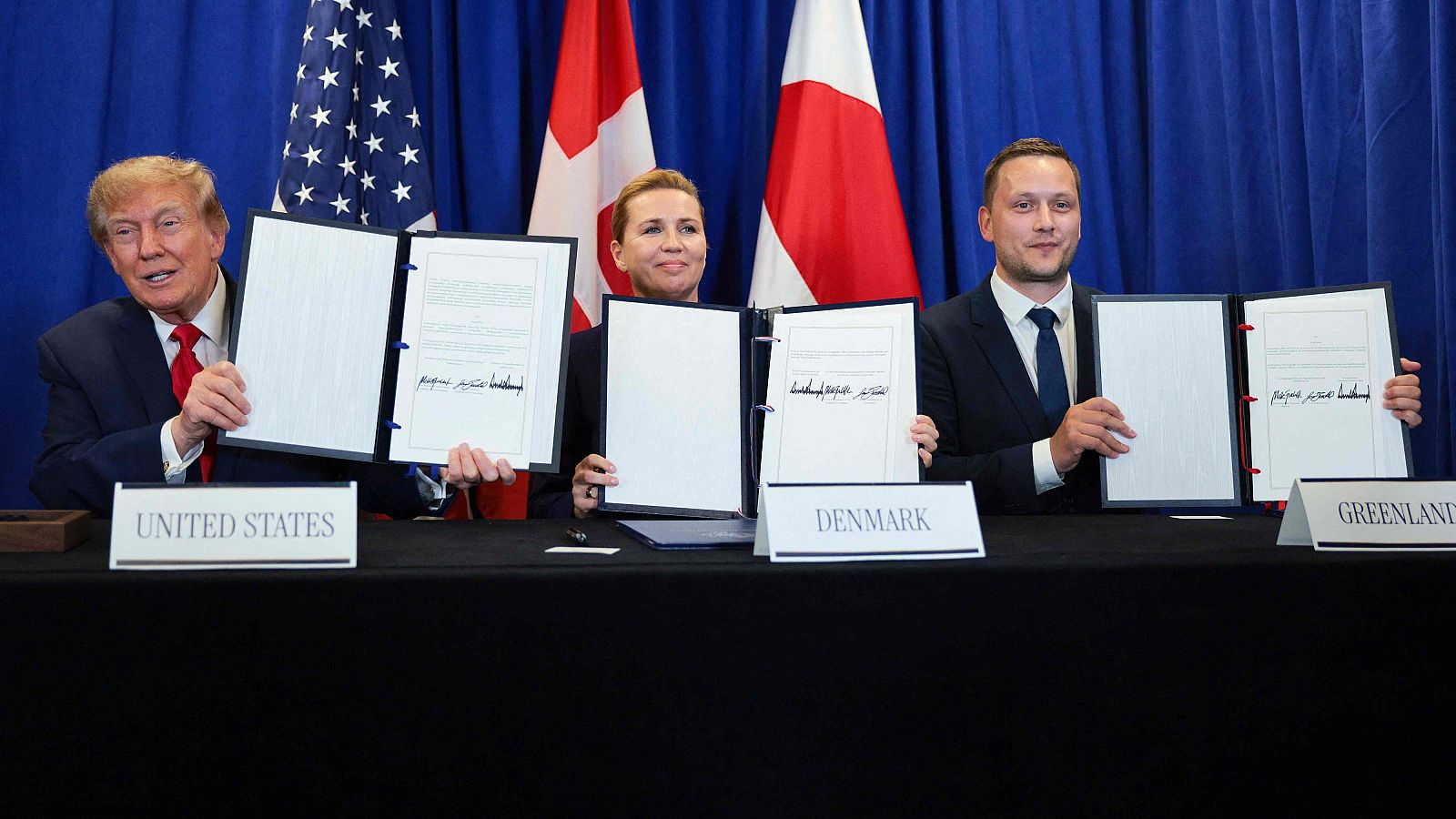 Donald Trump, Mette Frederiksen y Jens-Frederik Nielsen presentan documentos firmados, con sus banderas nacionales y carteles identificativos de Estados Unidos, Dinamarca y Groenlandia.