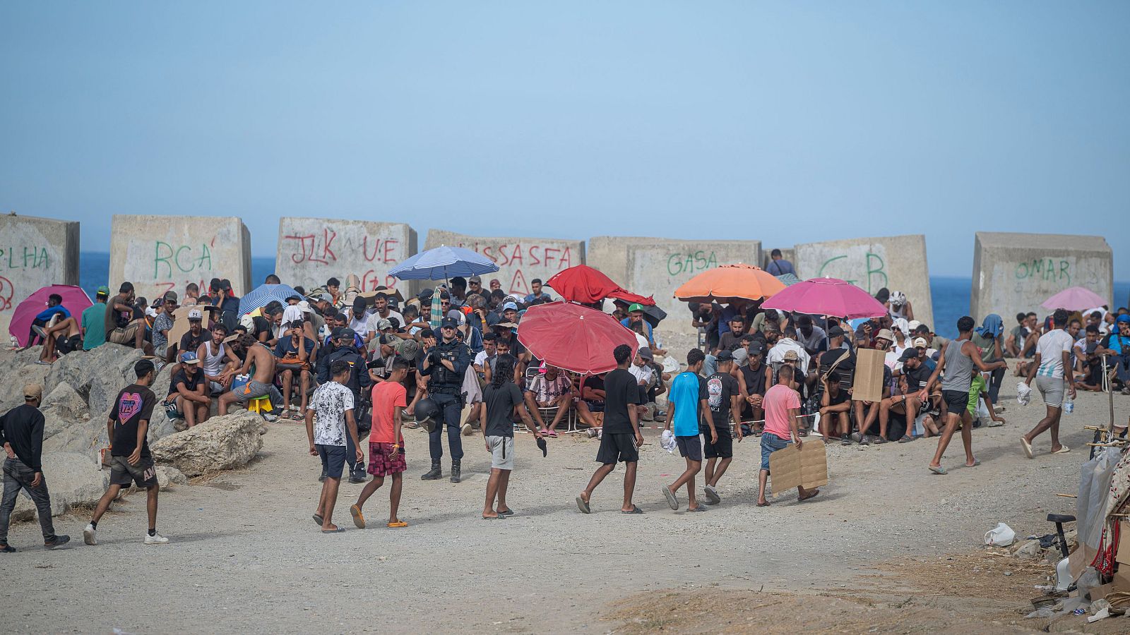 Varios migrantes acampados en la playa del Trampolín