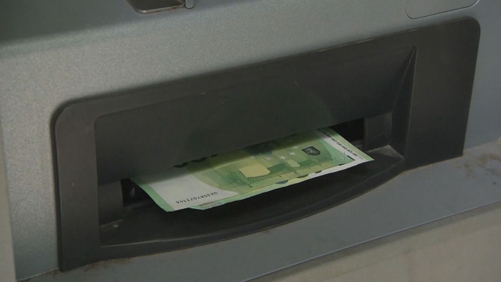 Extracció de bitllets de 100 euros d'un caixer automàtic en una imatge d'arxiu