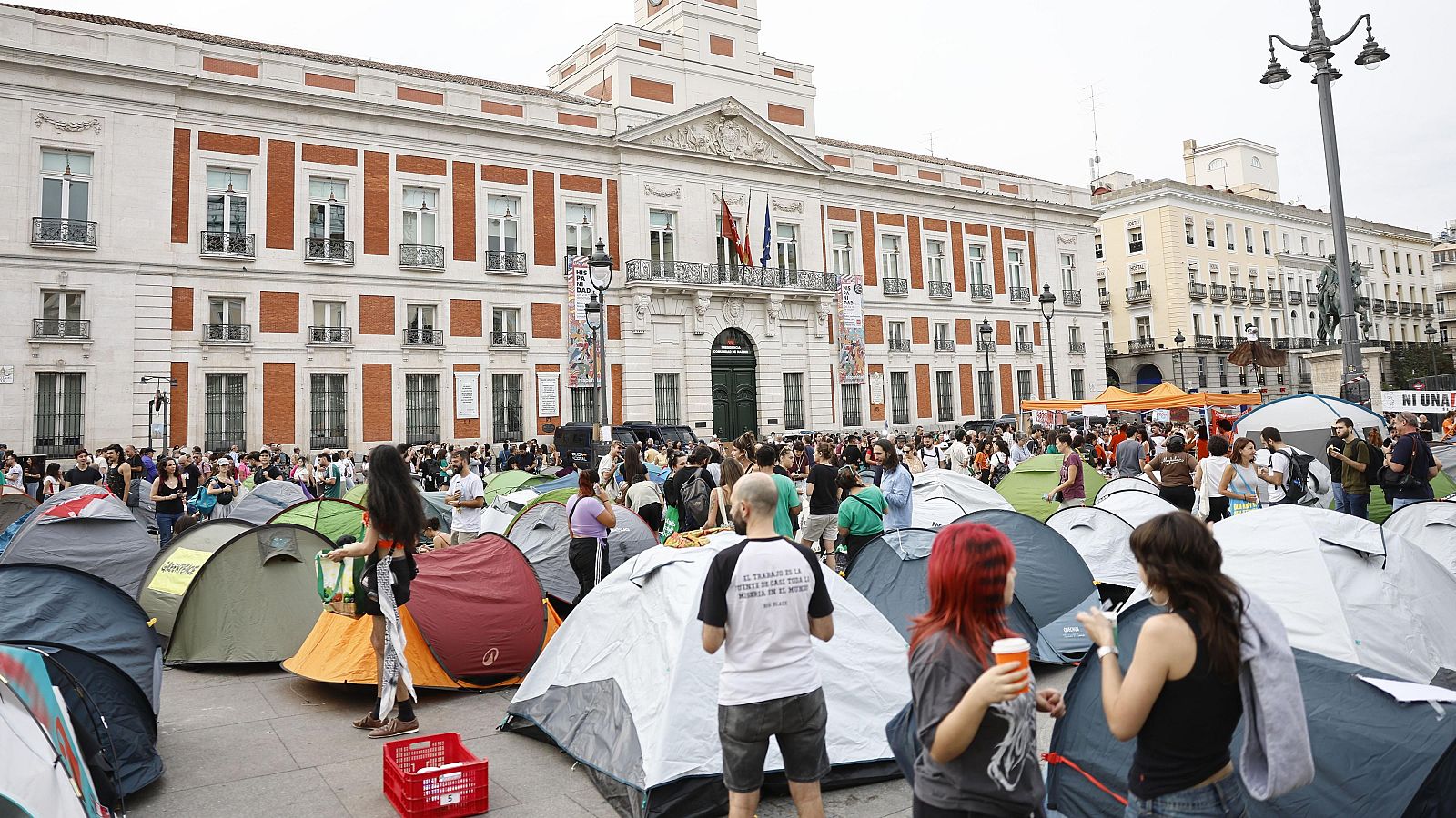 Desenes de tendes de campanya desplegades a la Puerta del Sol de Madrid, davant la seu del govern autonòmic