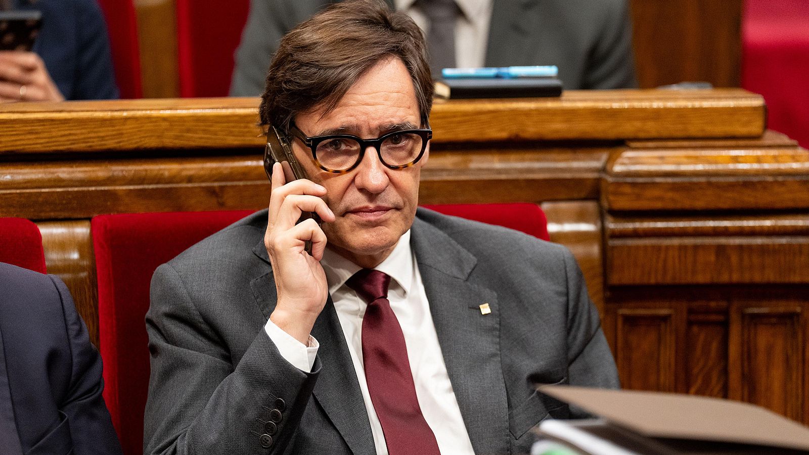 El president de la Generalitat, Salvador Illa, parlant per telèfon des de l'escó