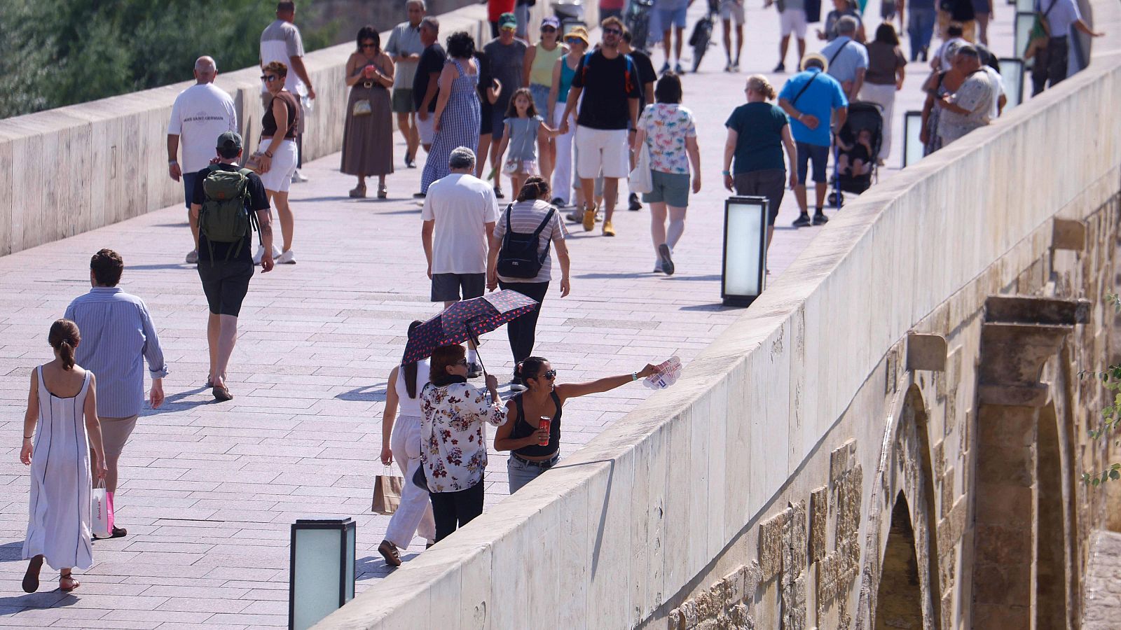 Turistas cruzan el Puente Romano de Córdoba.