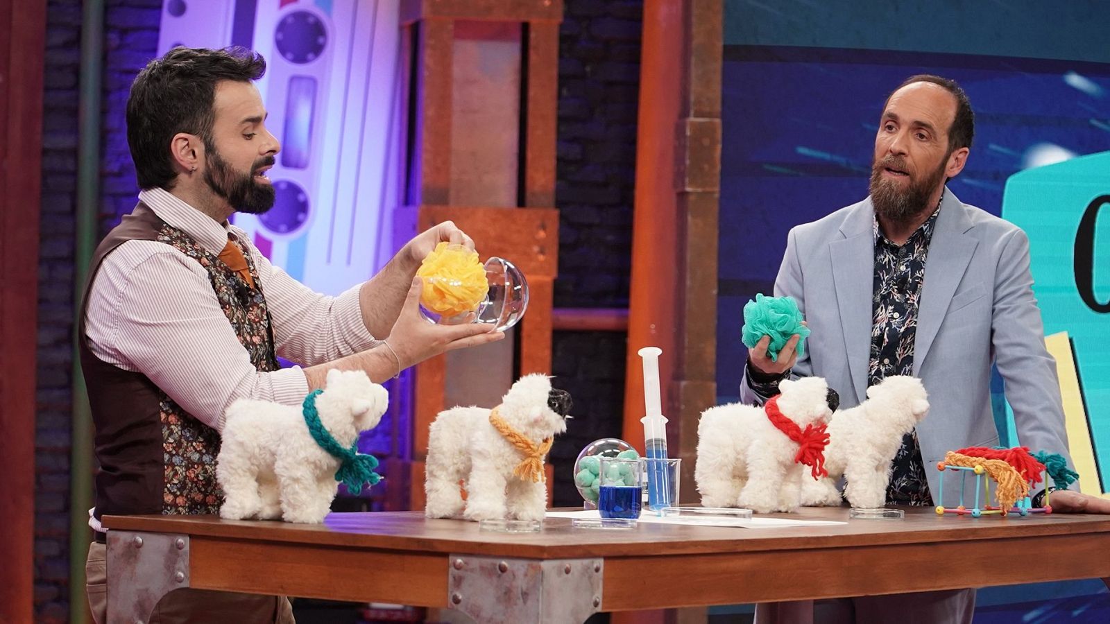 Ricardo Moure y Eduardo Sáenz de Cabezón participan en el programa Órbita Laika junto a una mesa con atrezzo científico y peluches de ovejas.