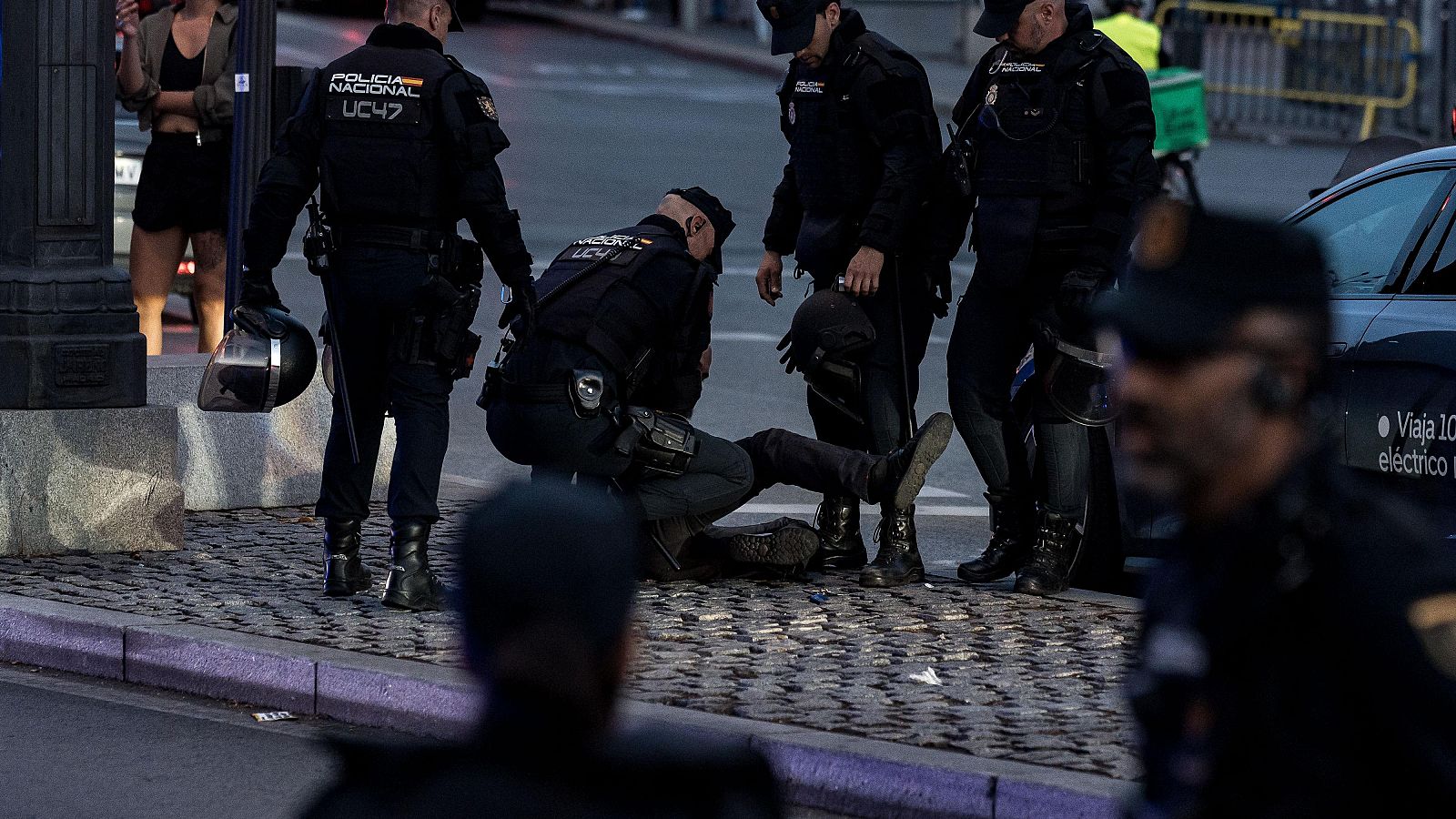 Varios agentes de la Policía Nacional detienen a un persona durante una concentración de protesta contra la acampada en la Puerta del Sol