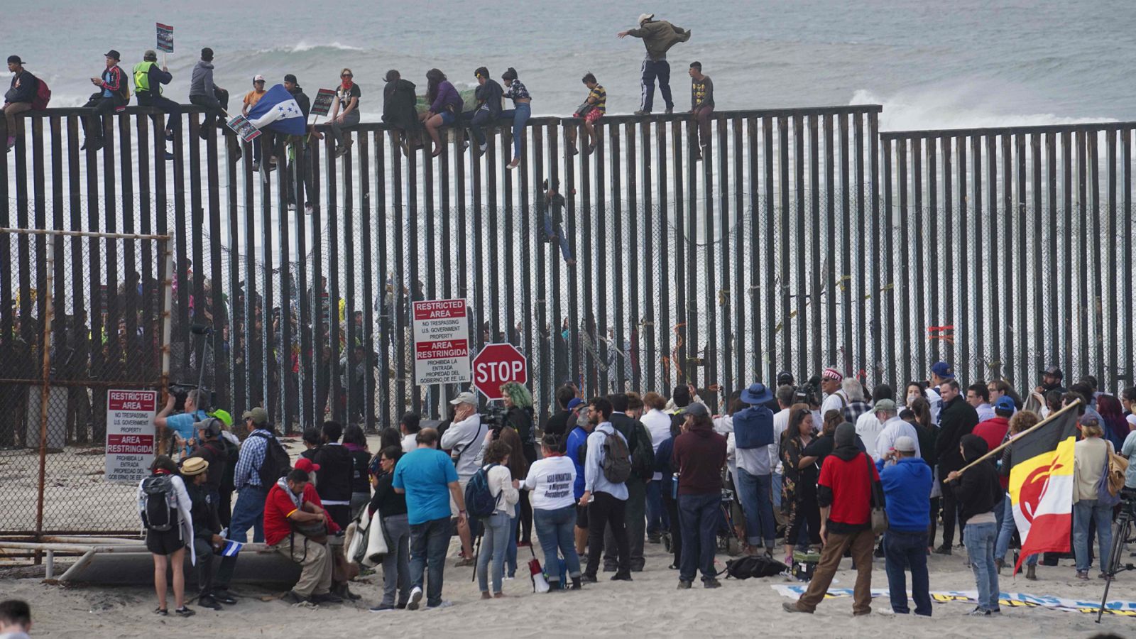 Migrantes centroamericanos escalan la valla fronteriza con EE.UU. en San Isidro, California
