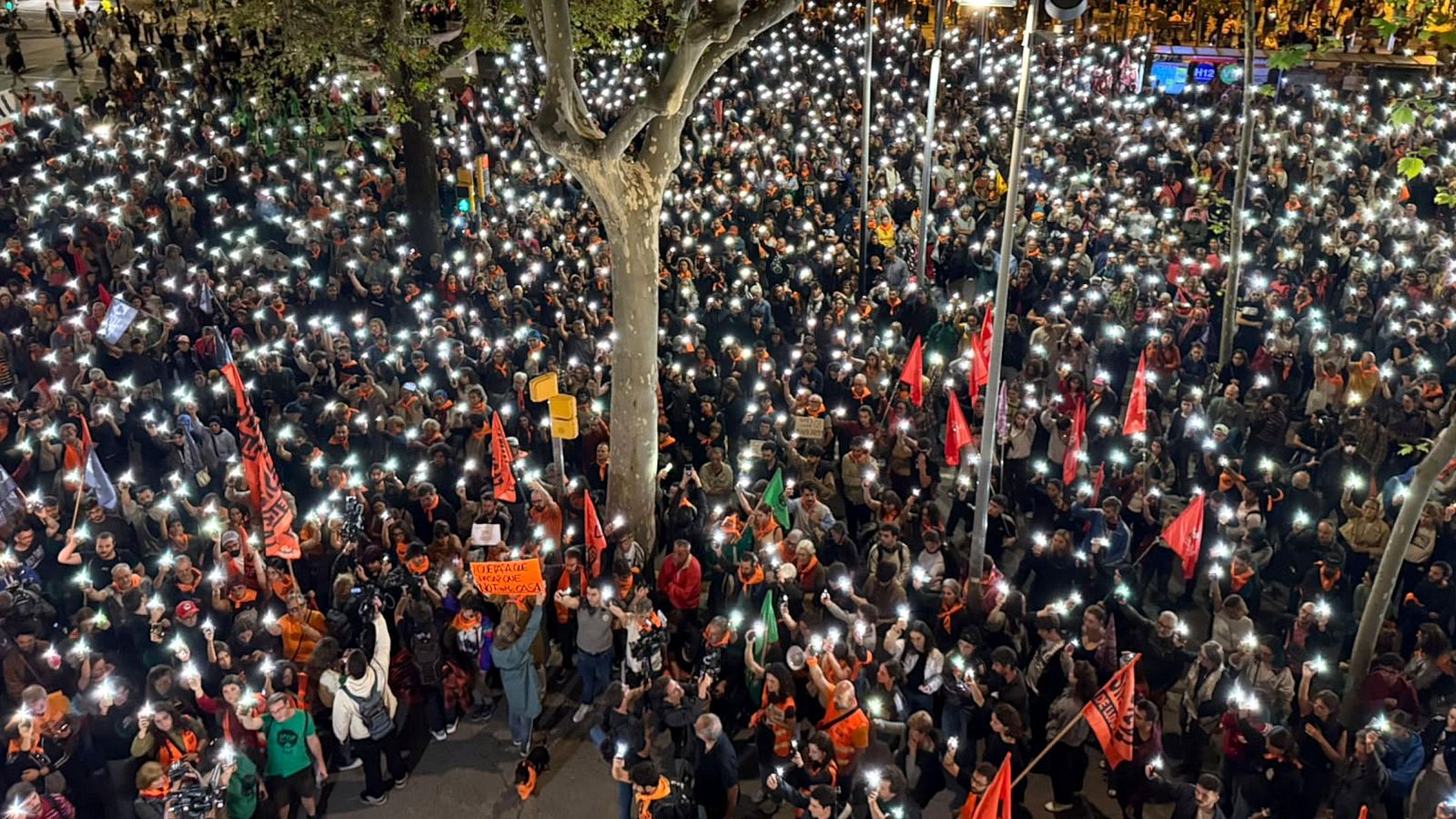Centenars de persones encenen la llinterna del mòbil mentre fan un minut de silenci per la Maricarmen a la plaça Universitat de Barcelona