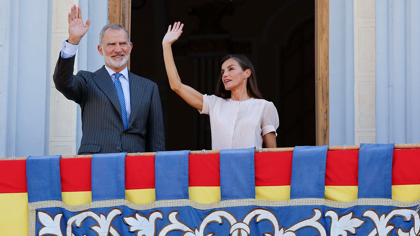 El rey Felipe VI (i) y la reina Letizia (d) saludan desde el balcón a los ciudadanos de Melilla este miércoles a su llegada a la ciudad autónoma