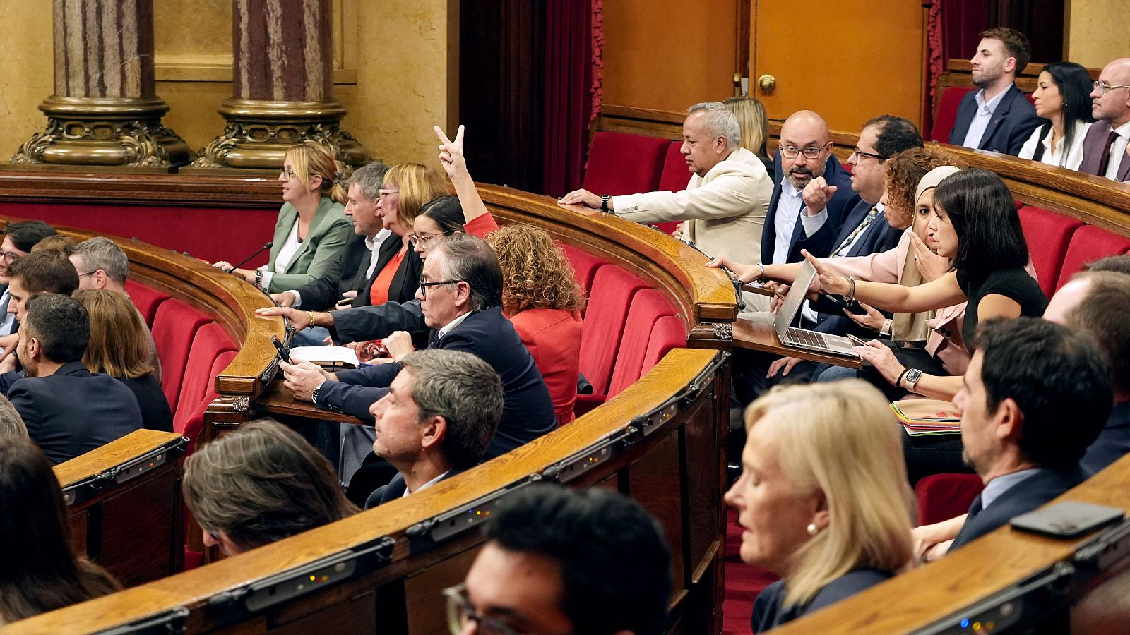 Vista parcial del ple del Parlament de Catalunya amb diputats votant i consultant ordinadors als escons.