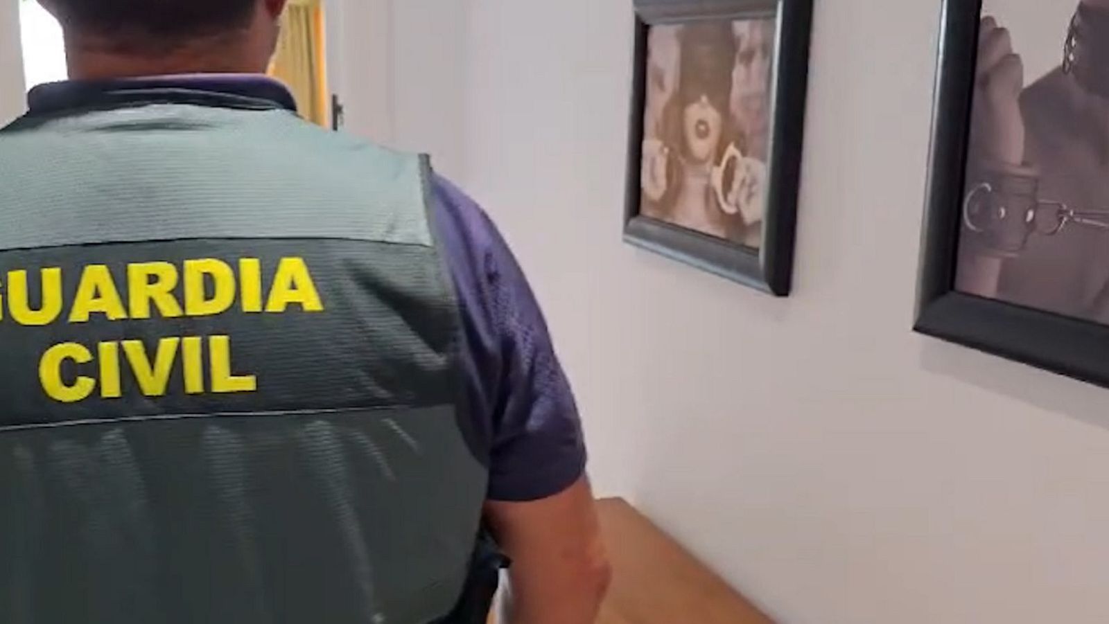 Un agente de la Guardia Civil de espaldas, luciendo el chaleco reflectante del cuerpo, durante la inspección y registro del interior de un inmueble utilizado para la explotación sexual