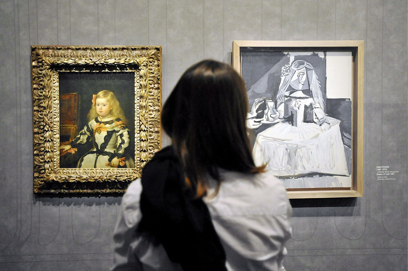 Una mujer observa las obras "La infanta María Margarita", de los pintores españoles Pablo Picasso (d) y Diego Velázquez (i) respectivamente, en la exposición "Picasso y los Maestros"