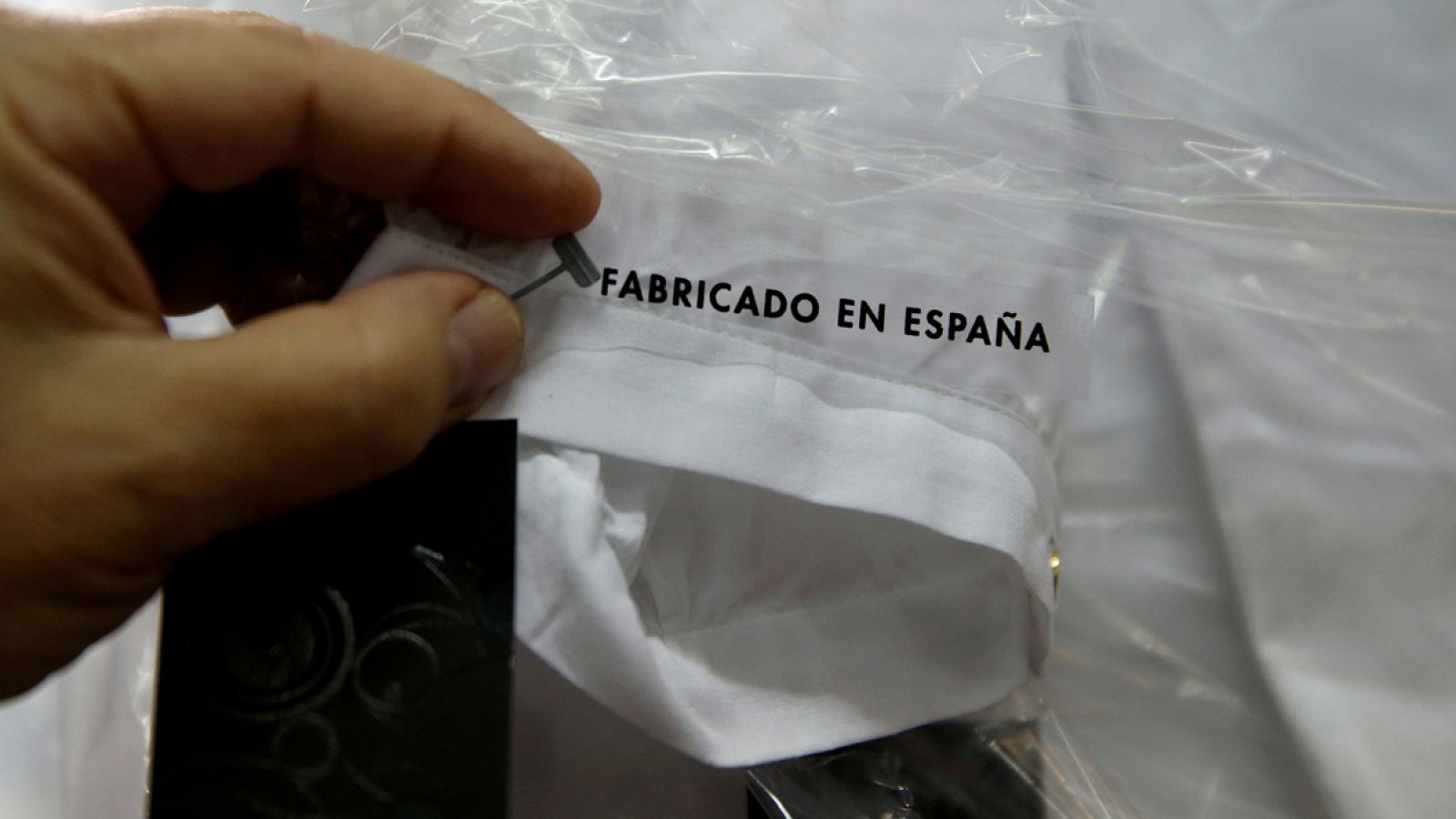 Un empleado textil revisa una camisa