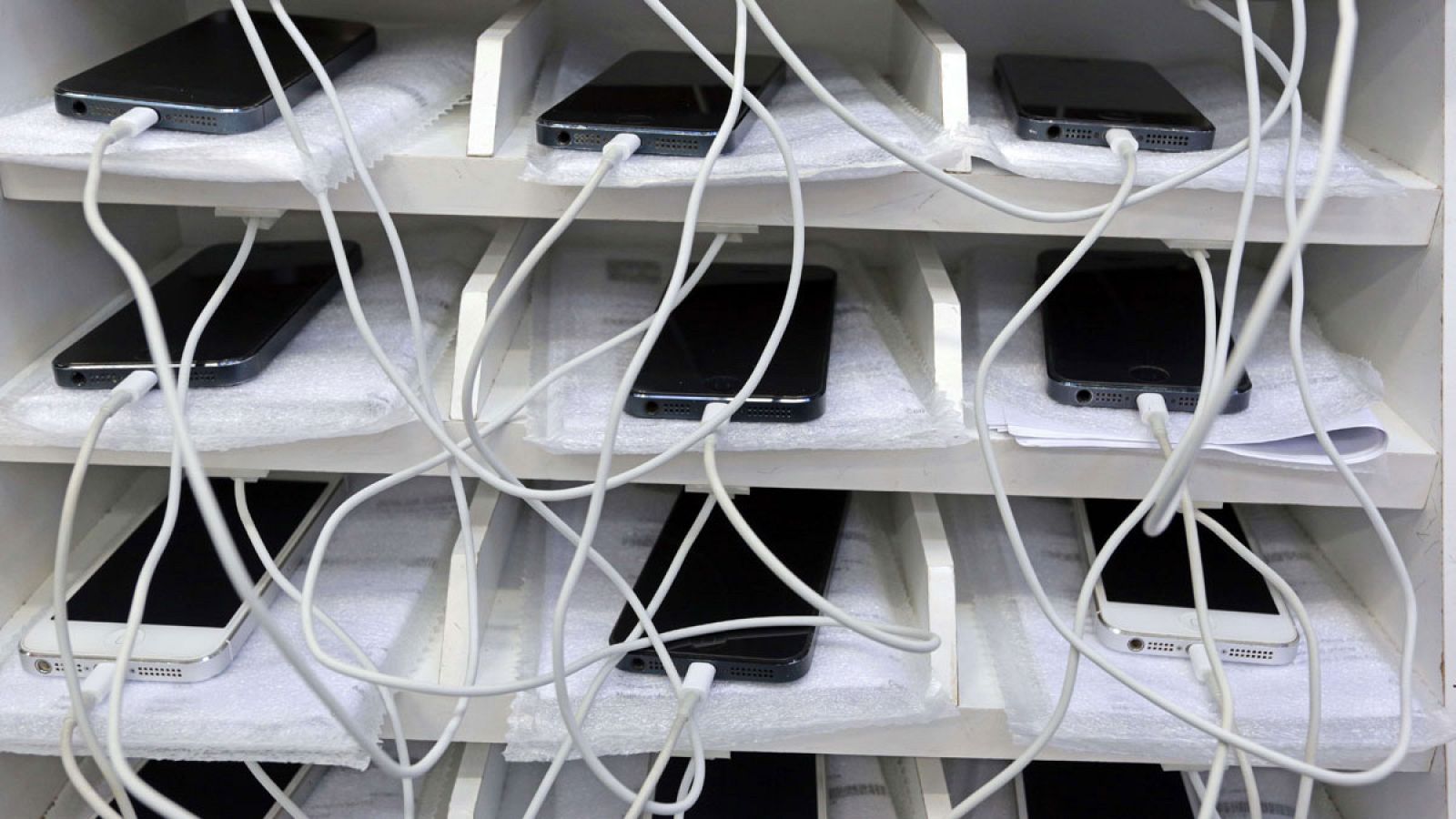 Varios teléfonos móviles en las estanterías de una tienda de reciclaje de dispositivos