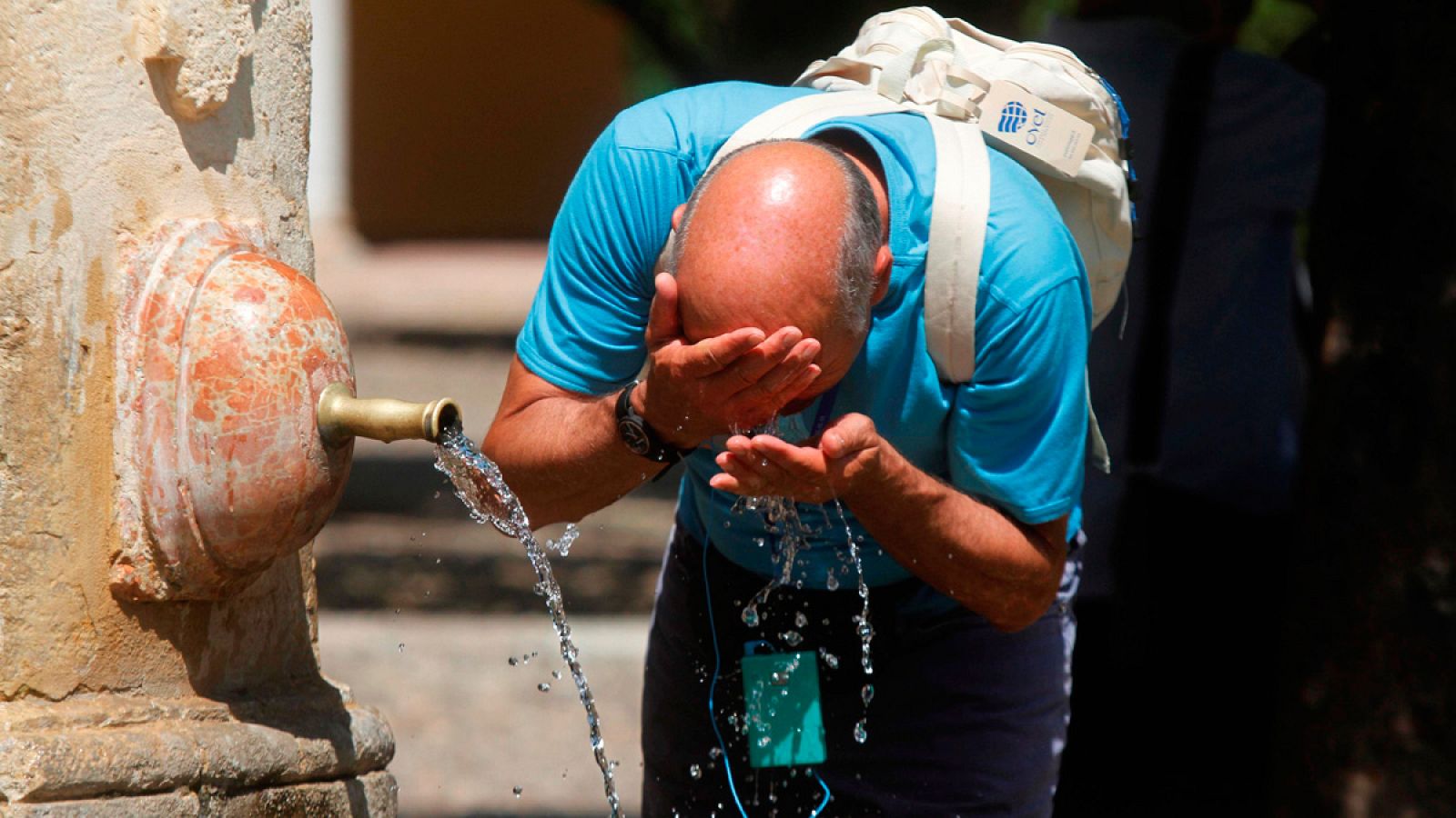 Un hombre se refresca en la fuente del Patio de los Naranjos, de la Mezquita Catedral de Córdoba, en una imagen de archivo