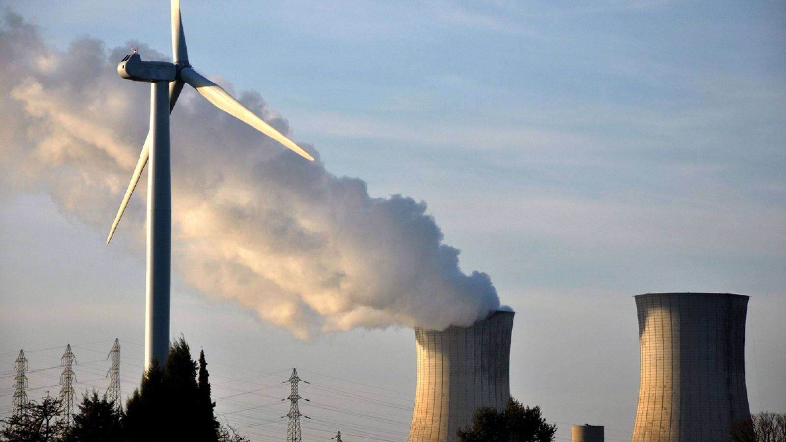 Imagen de archivo de una central eléctrica junto a un generador de energia eólica