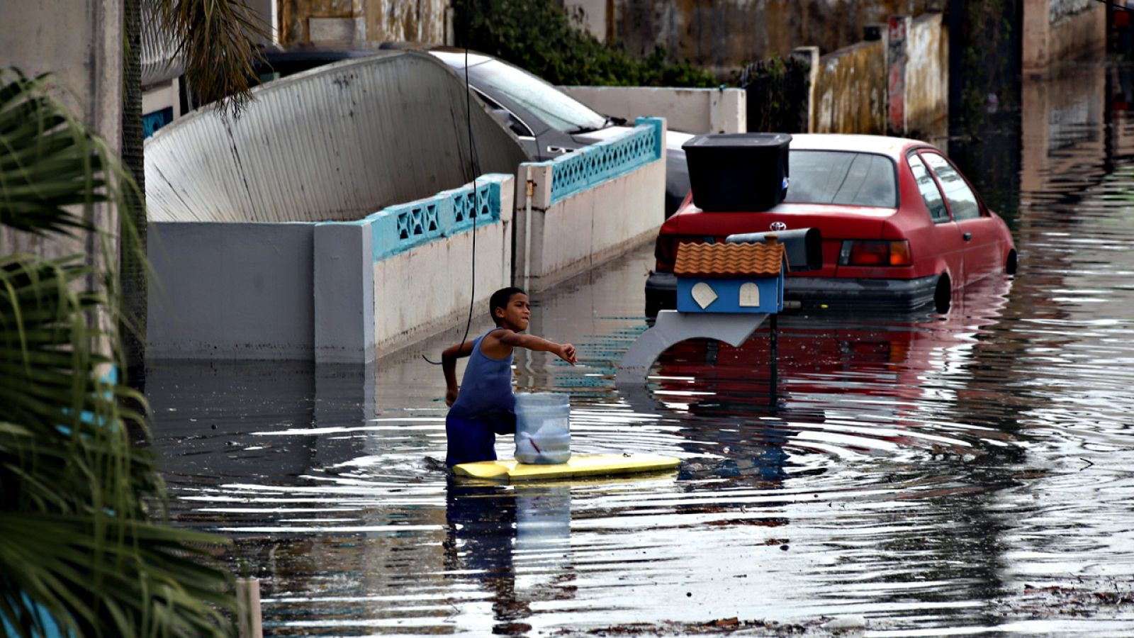 Un niño pasa por una calle inundada de Cataño, en Puerto Rico, tras el paso del huracán María