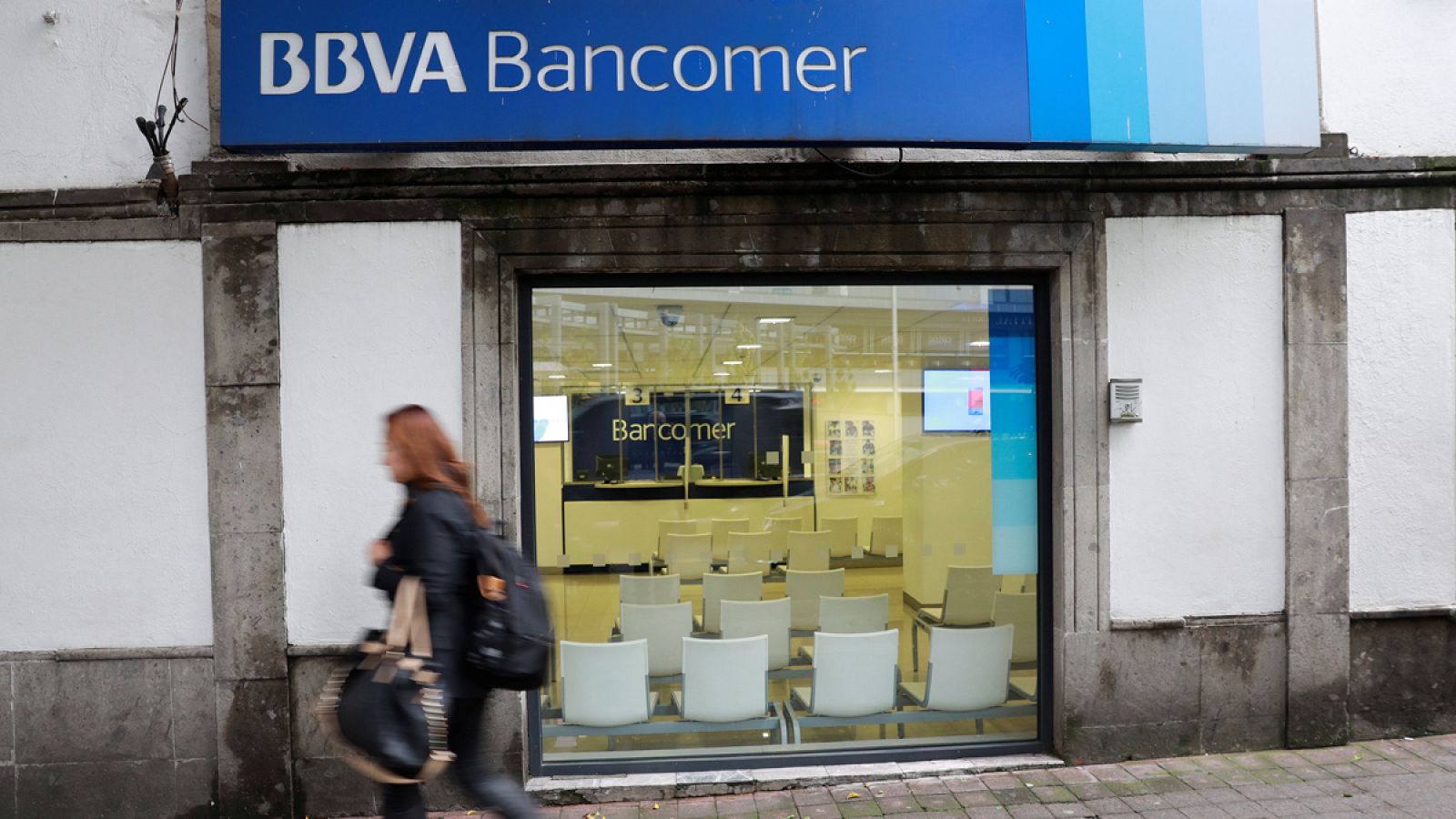 Una mujer pasa por delante de una sucursal de BBVA en Ciudad de México