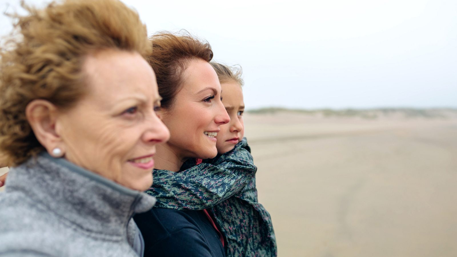 Tres mujeres de generaciones diferentes miran al mar
