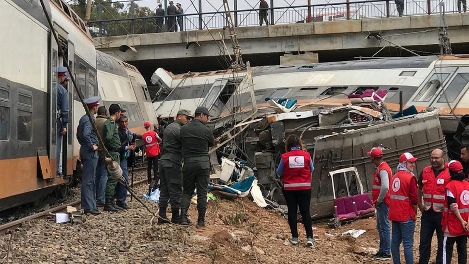 Miembros de los equipos de emergencias y seguridad en el lugar del descarrilamiento de un tren en Sidi Bouknadel, cerca de Rabat, Marruecos