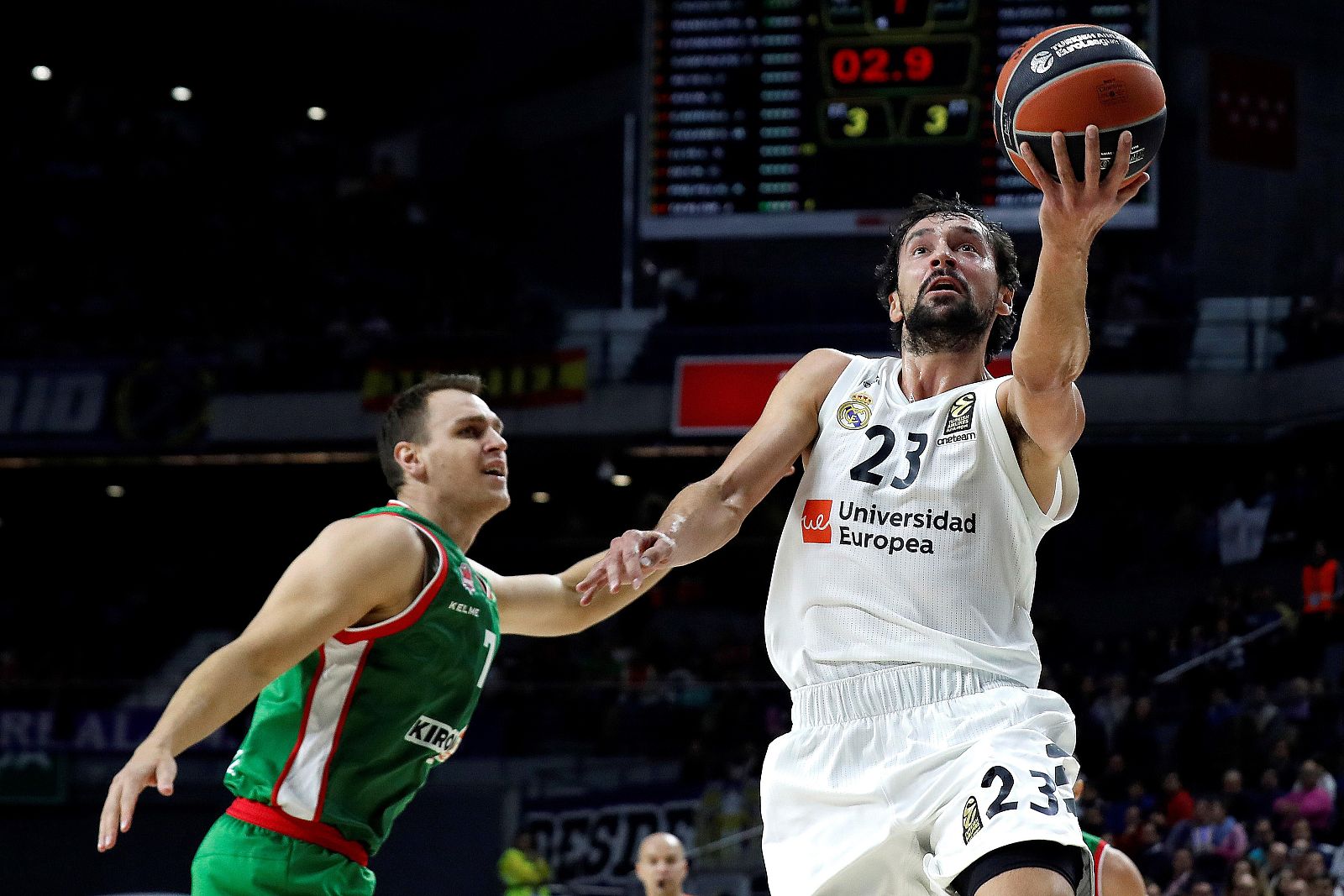 El base del Real Madrid Sergio Llull (d) supera al pivot alemán del Kirolbet Baskonia Johannes Voigtmann durante el partido.