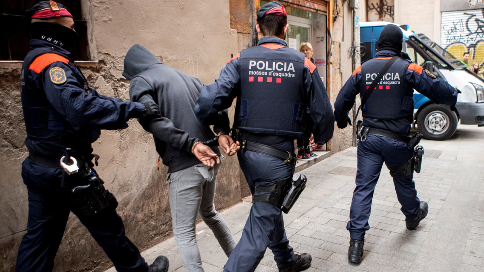 Los mossos con un detenido de los "narcopisos"