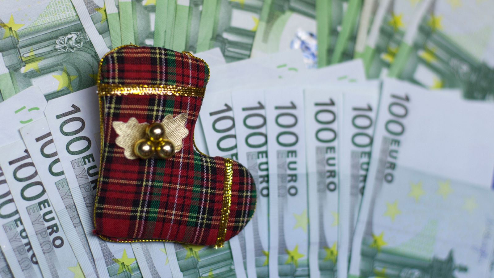 Un calcetín navideño sobre billetes de cien euros