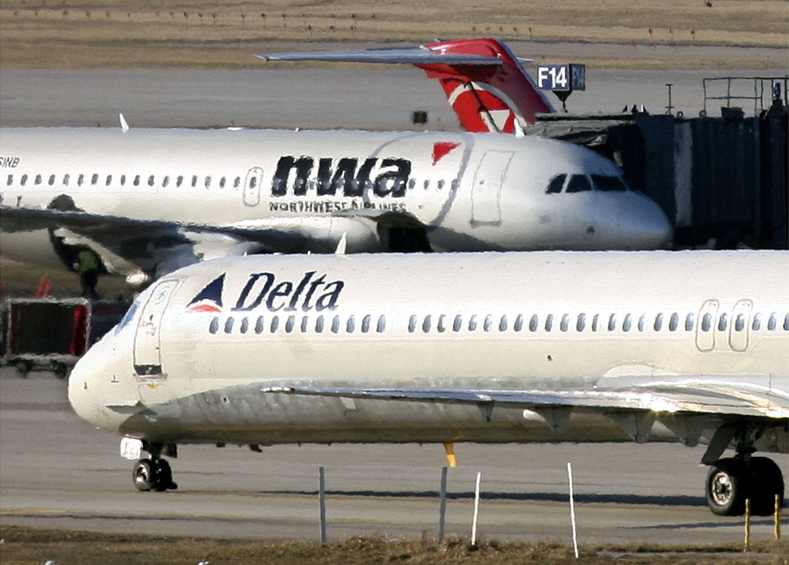File photo of Delta Air Lines jet taxiing past a Northwest Airlines jet at St. Paul International Airport in Minnesota