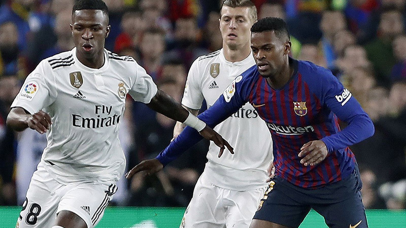 El delantero brasileño del Real Madrid, Vinicius Júnior (i), pelea un balón con el delantero brasileño del FC Barcelona, Malcom (d), en el partido de ida.