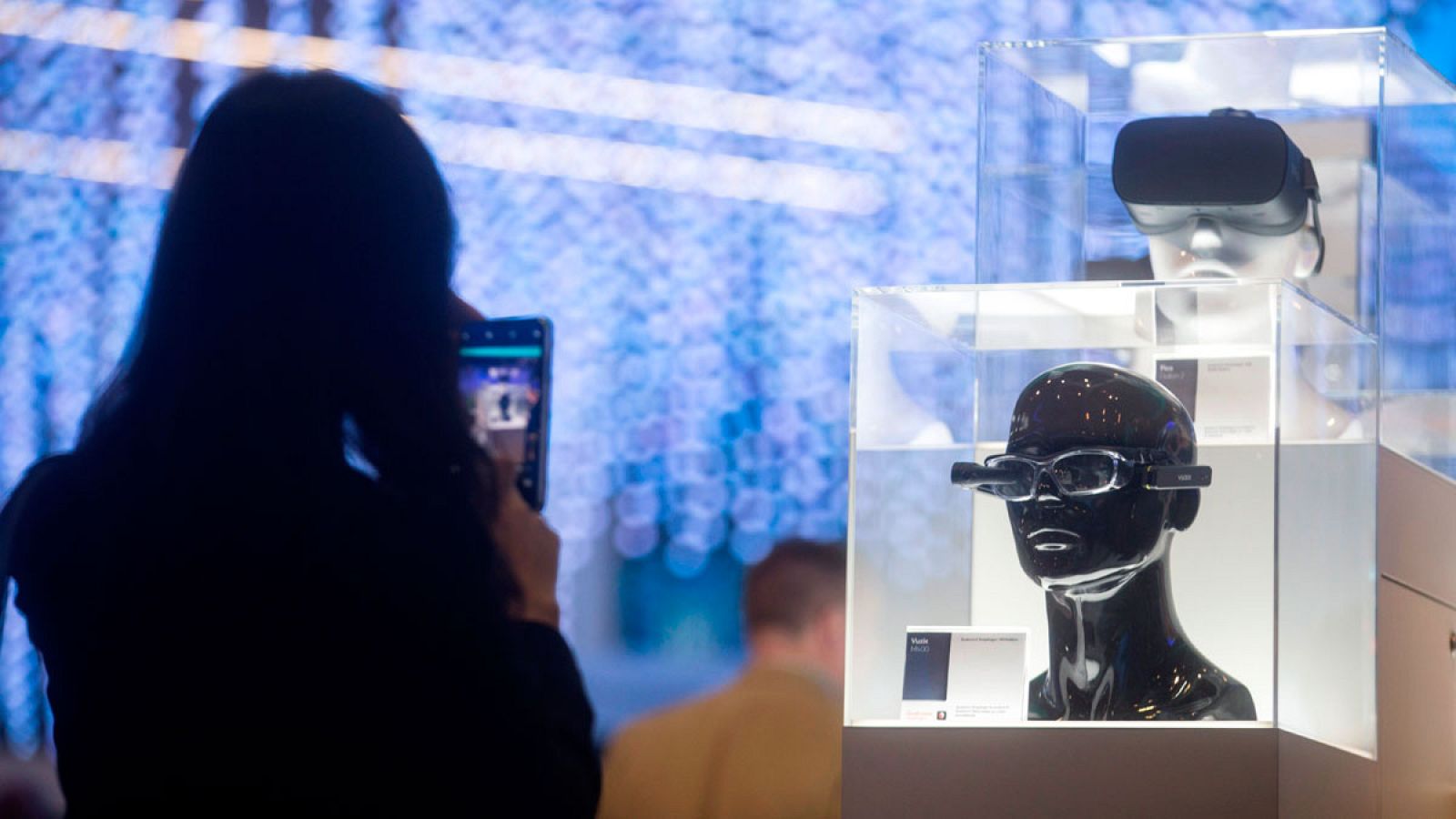 Una mujer fotografía un dispositivo tecnológico durante el Mobile World Congress.