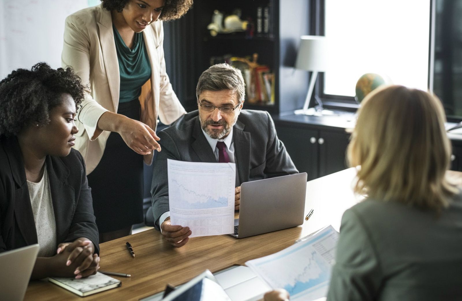 Fotografía de recurso de tres mujeres y un hombre trabajo en una oficina