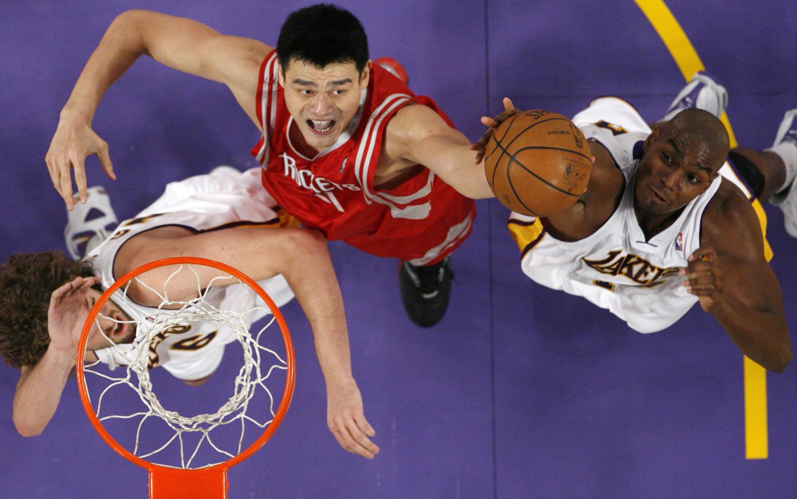 Yao Ming lucha por el rebote con Pau Gasol y Andrew Bynum, de los Lakers