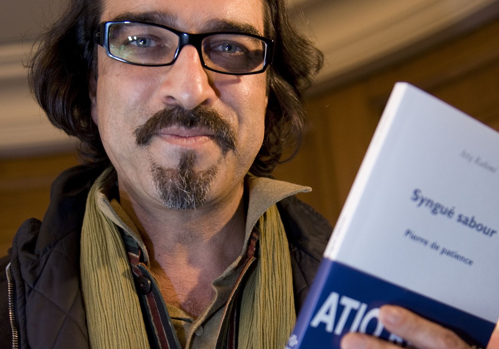 Afghan author Rahimi poses with his book Syngue Sabour after winning the Goncourt literary prize in Paris