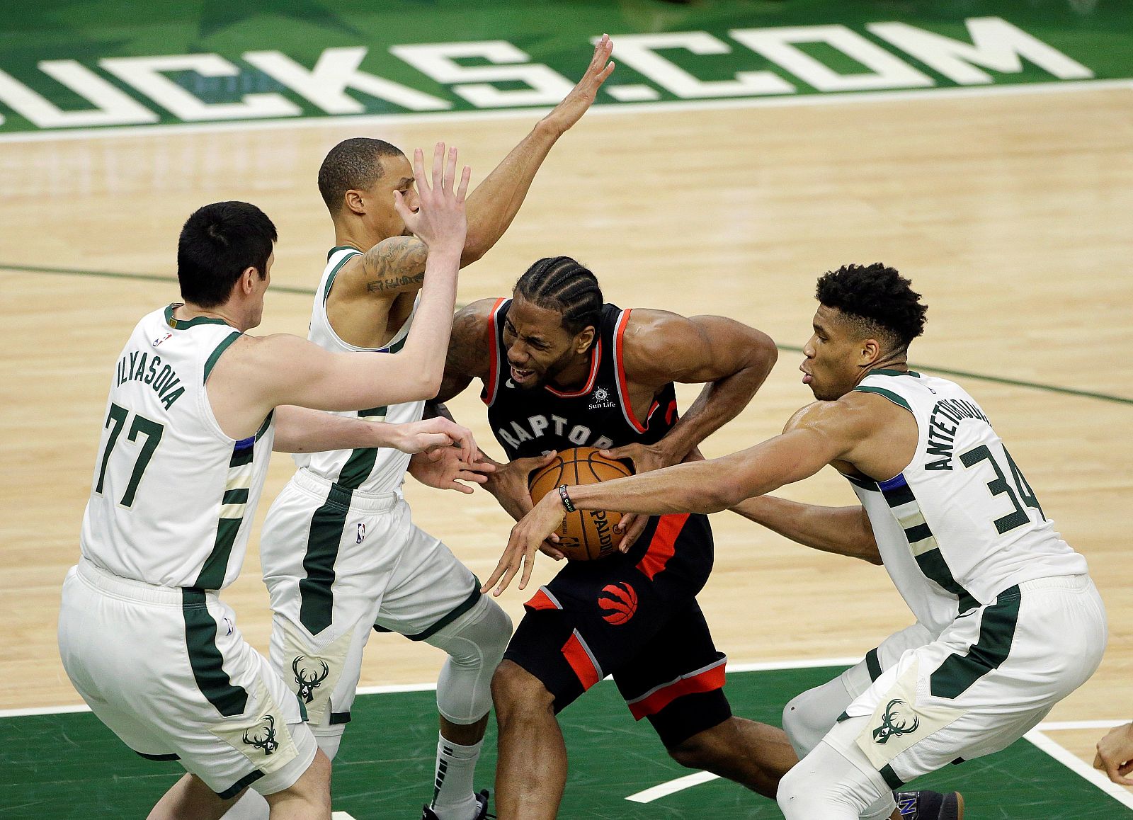 Jugadores de los Bucks tratan de parar a Kawhi Leonard