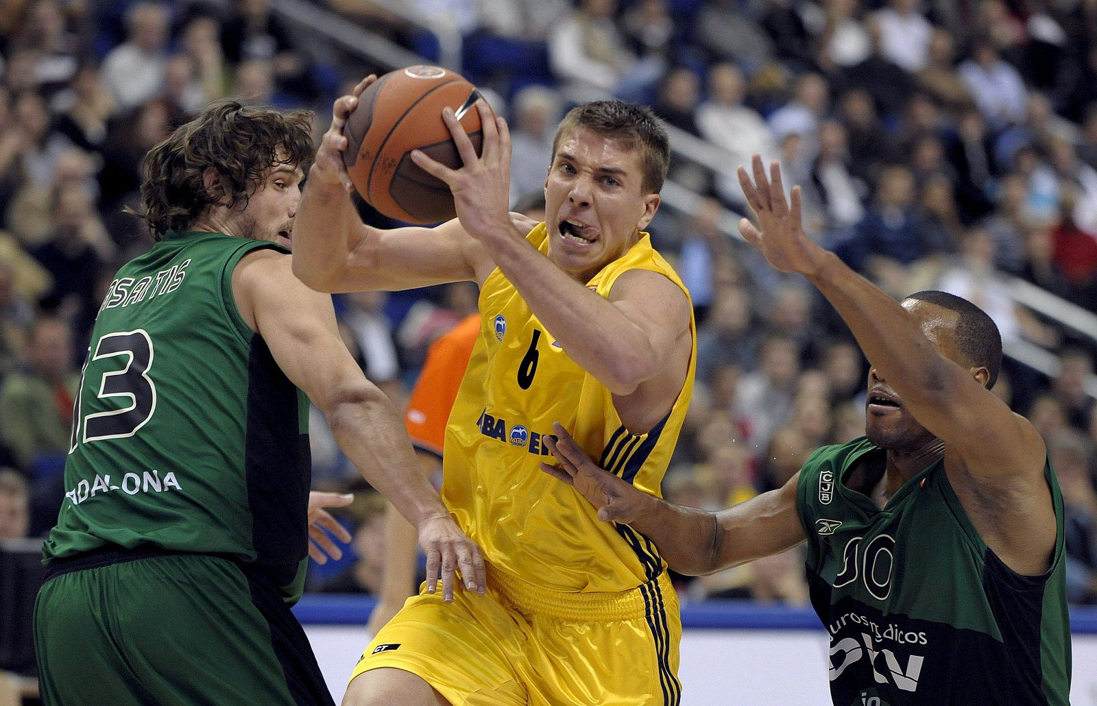 El jugador del Alba de Berlín, Hamann, trata de pasar ante la presencia de los jugadores del DKV Jasaitis y Mallet.