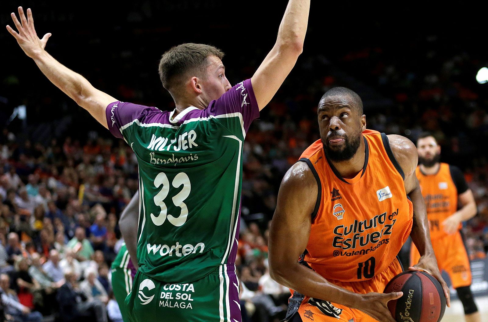 El ala pivot estadounidense del Valencia Basket Will Thomas (d) intenta superar al ala pivot canadiense del Unicaja de Málaga Kyle Wiltjer, durante el tercer partido del playoff de cuartos de final de la Liga Endesa que se disputa esta noche en el Pa
