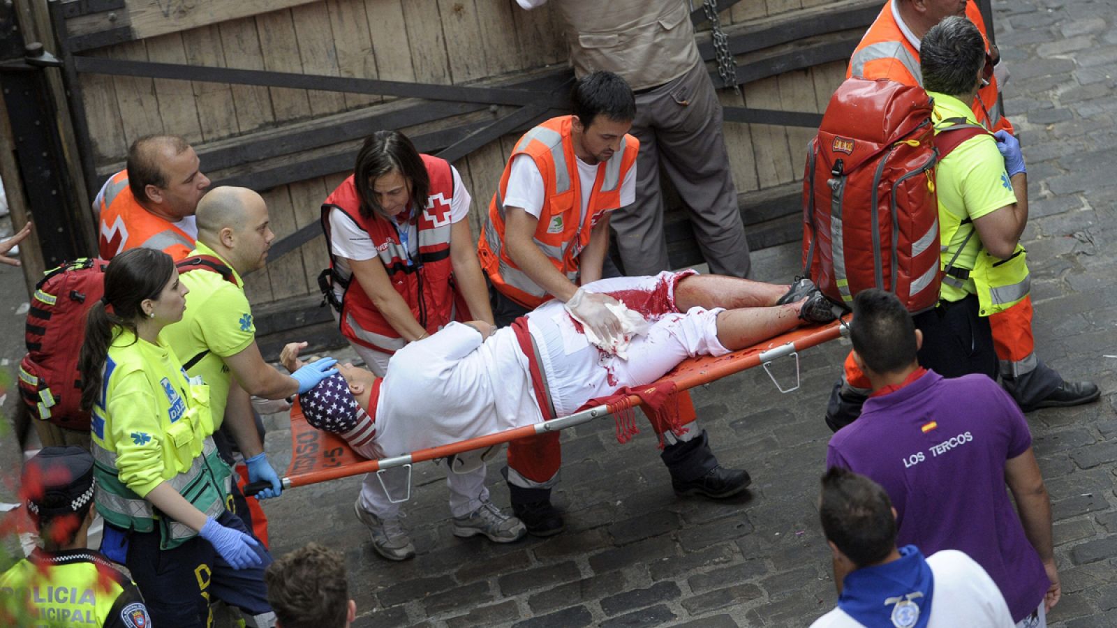 Un mozo es trasladado por los servicios sanitarios tras ser corneado en los encierros de Sanfermines