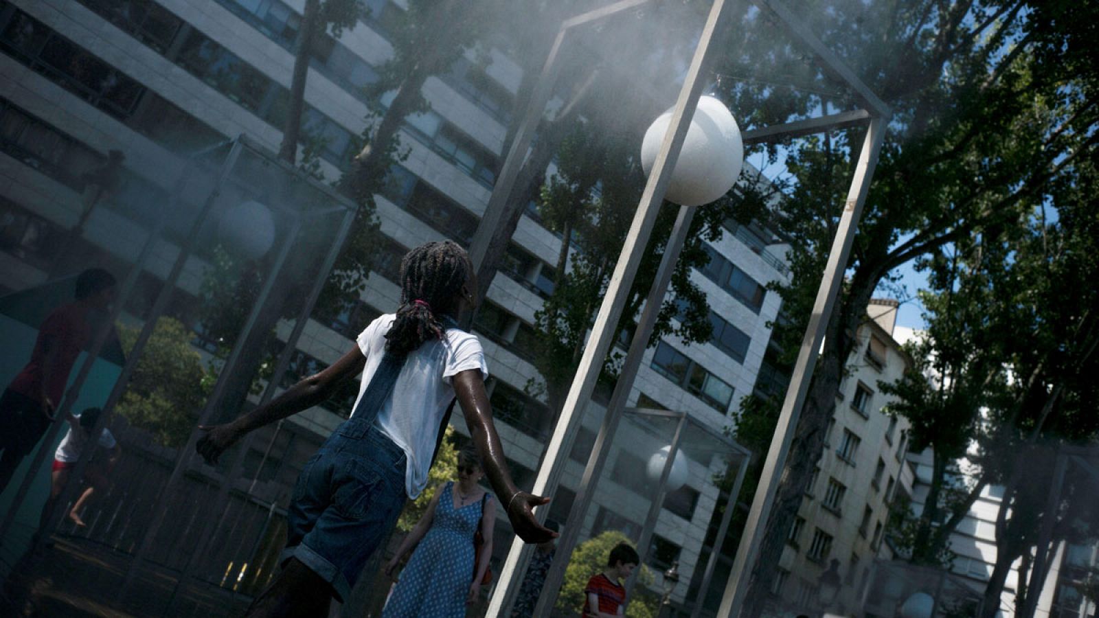 Niña refrescándose en la calle en París