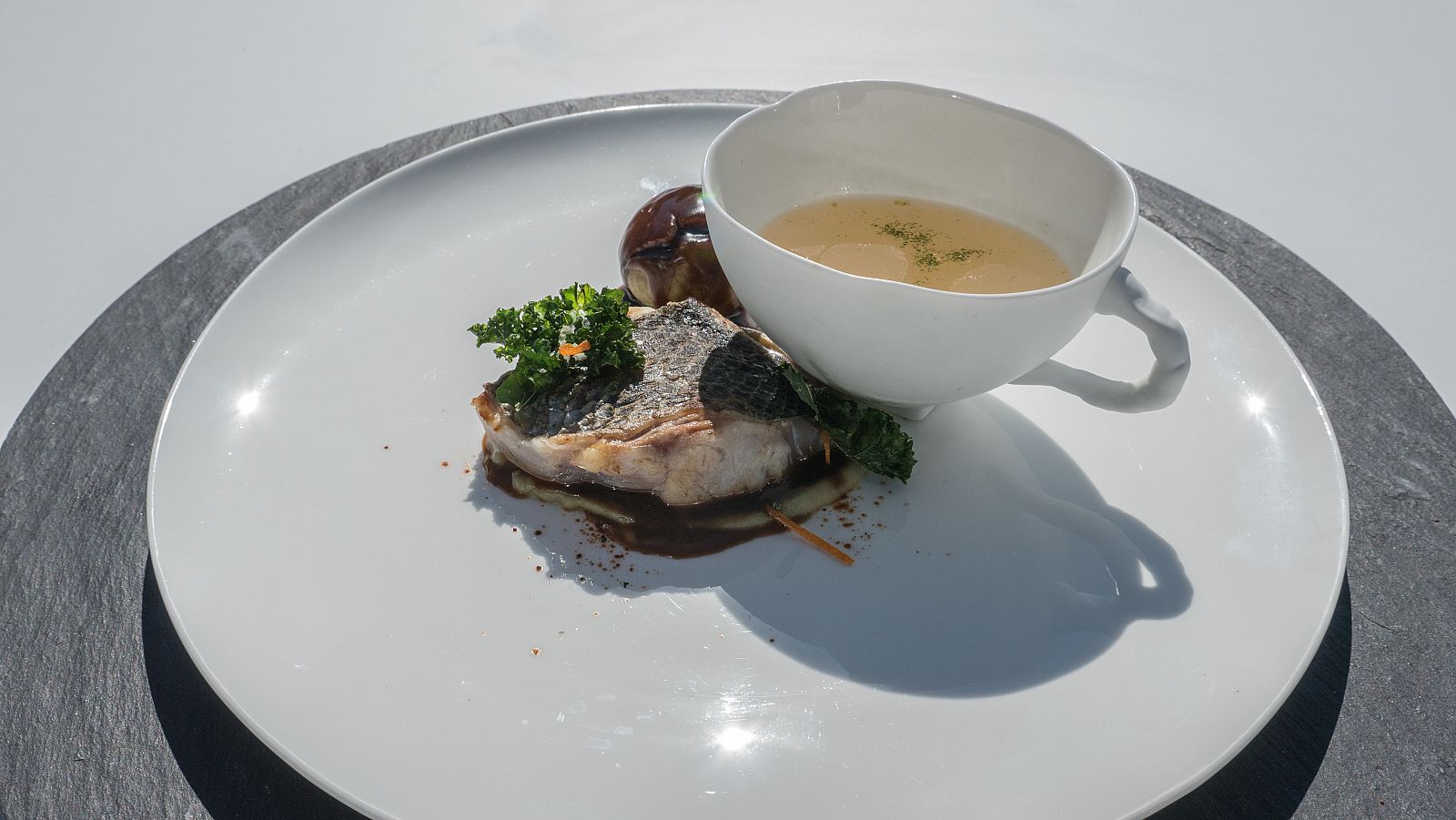 Receta de lubina asada con texturas de col, jugo de espinas, perol, pieles de naranja y polvo especiado